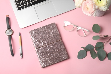 Photo of Blogger's workplace with laptop and notebook on color background, flat lay