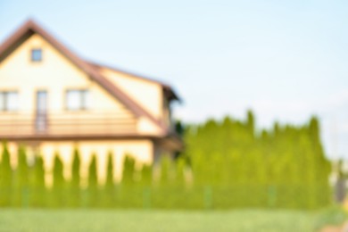 Blurred view of house and beautiful green trees on sunny day