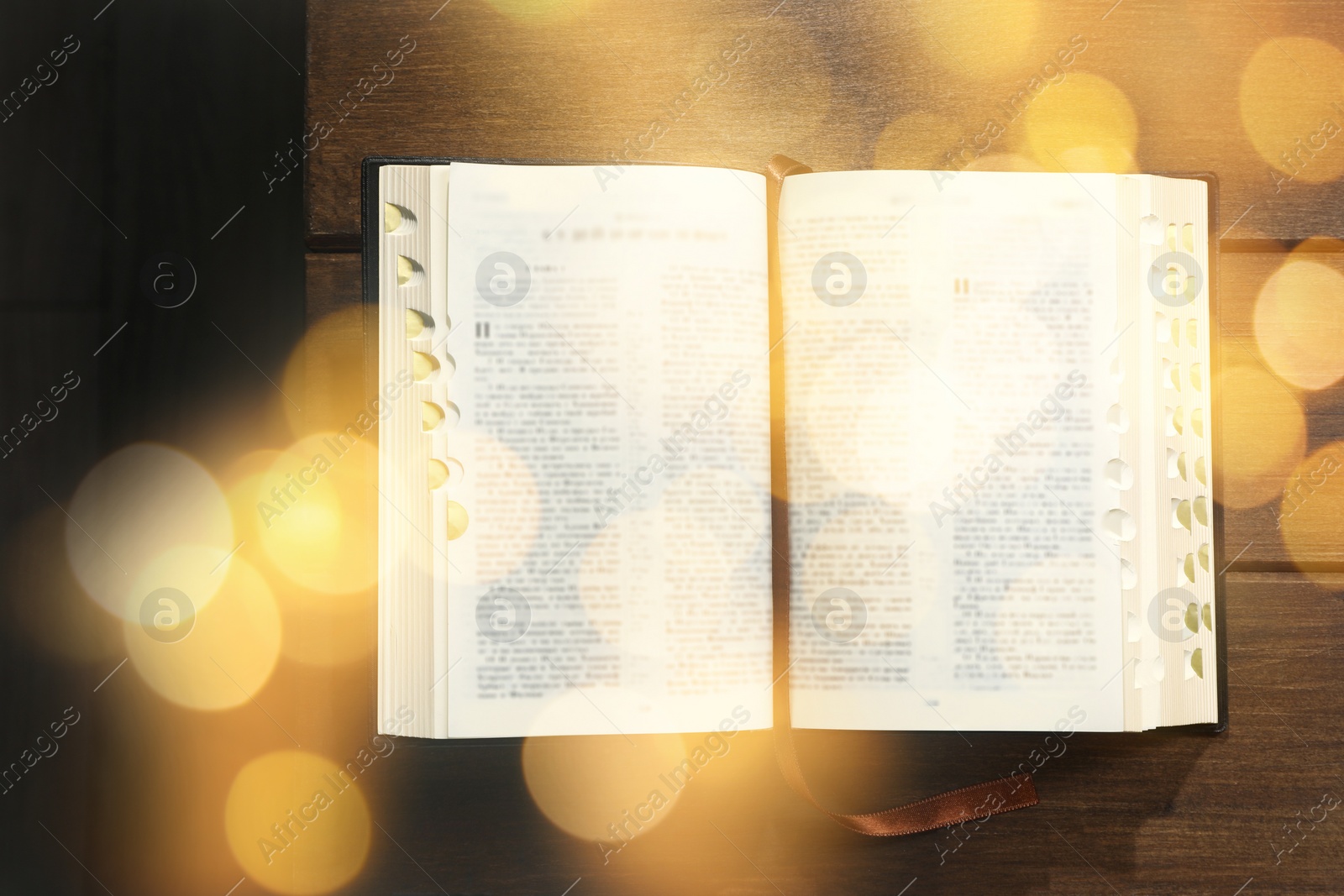 Image of Open Bible on wooden table, top view. Bokeh effect