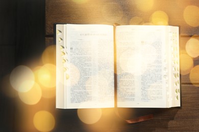 Image of Open Bible on wooden table, top view. Bokeh effect