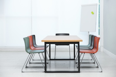 Photo of Conference room interior with wooden table and flipchart