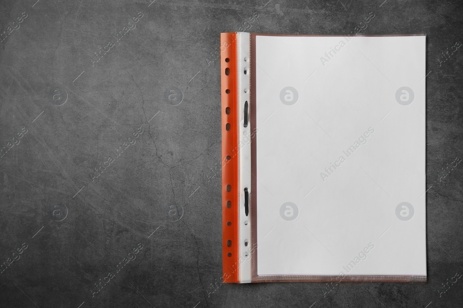 Photo of File folder with punched pockets on grey table, top view. Space for text