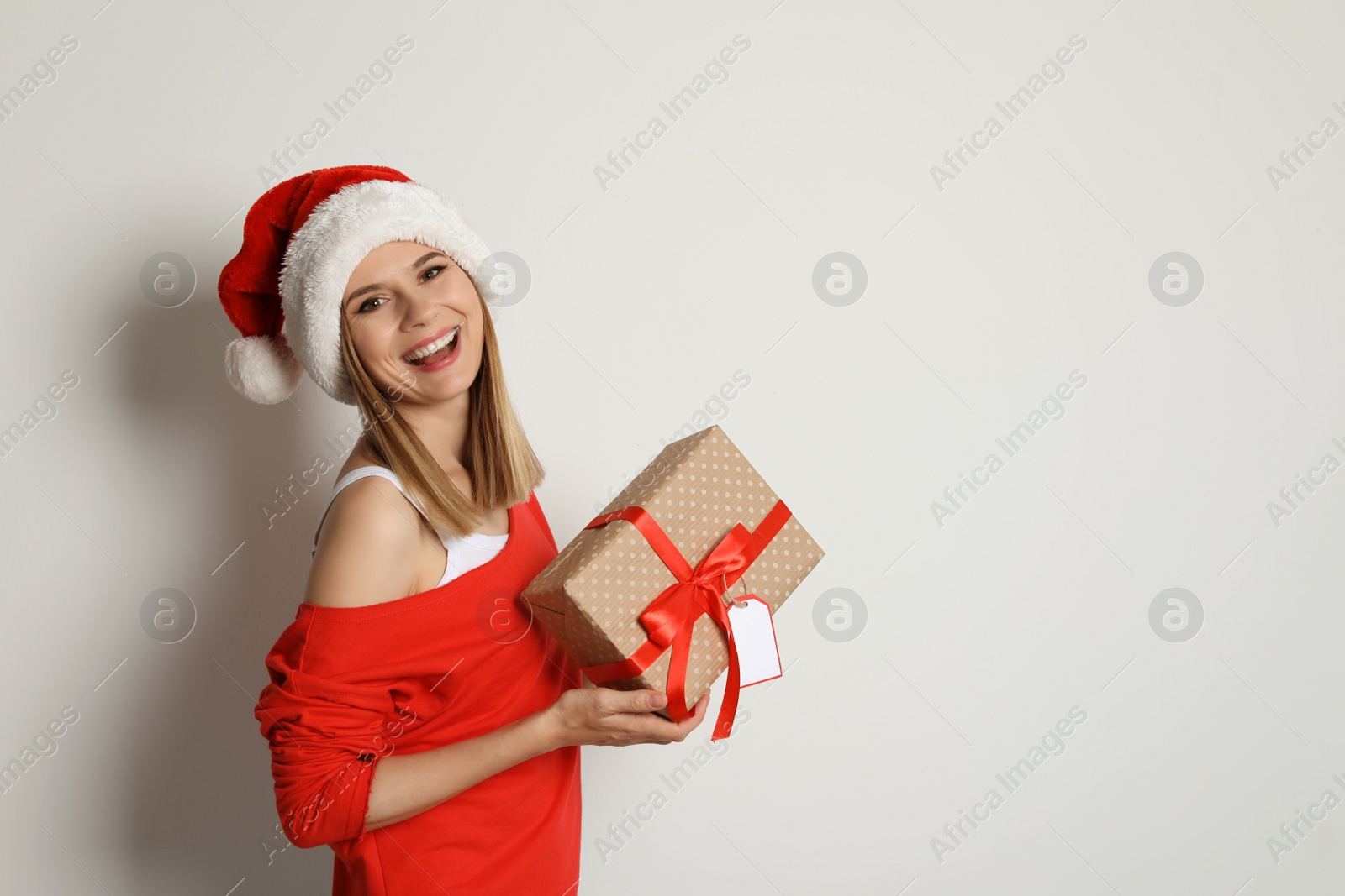 Photo of Young woman with Christmas gift on white background