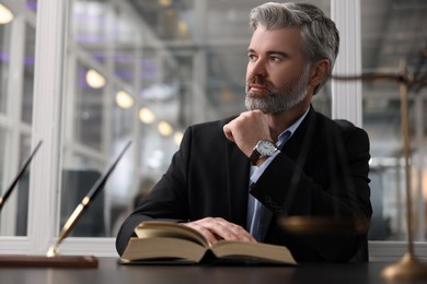 Photo of Portrait of confident lawyer at table in office
