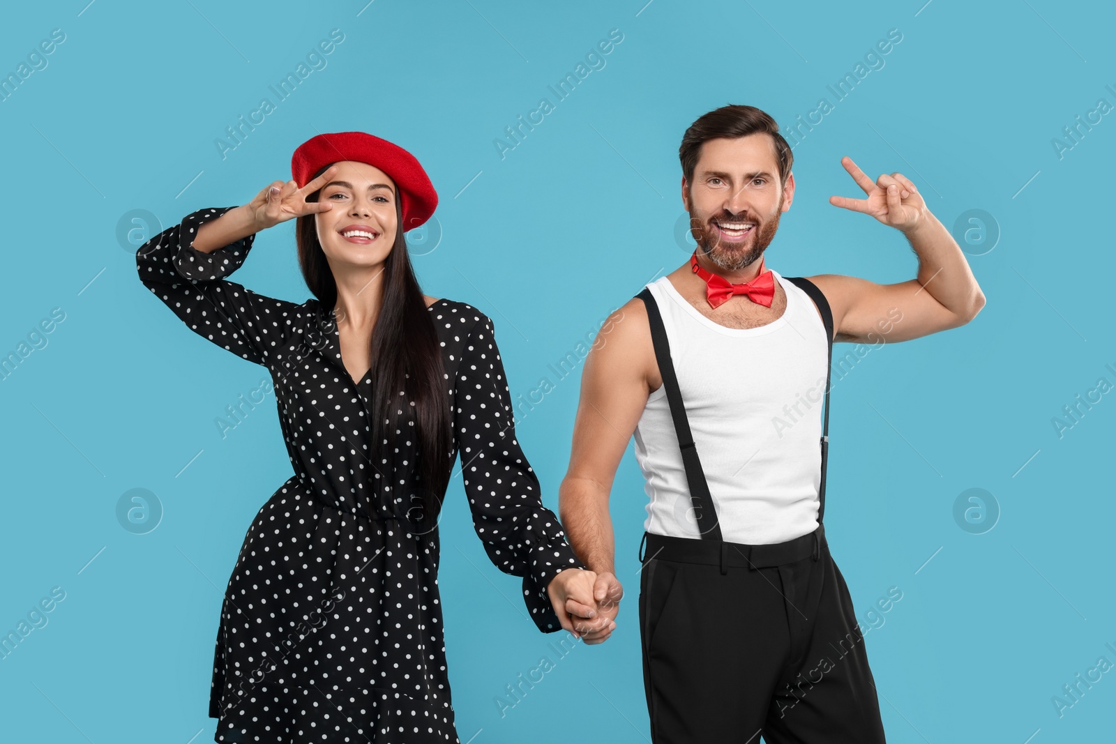 Photo of Happy couple dancing together on light blue background