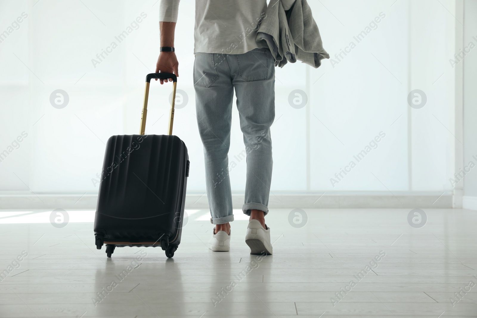 Photo of Man with black travel suitcase in airport