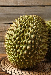 Photo of Ripe durians on wooden table, closeup view