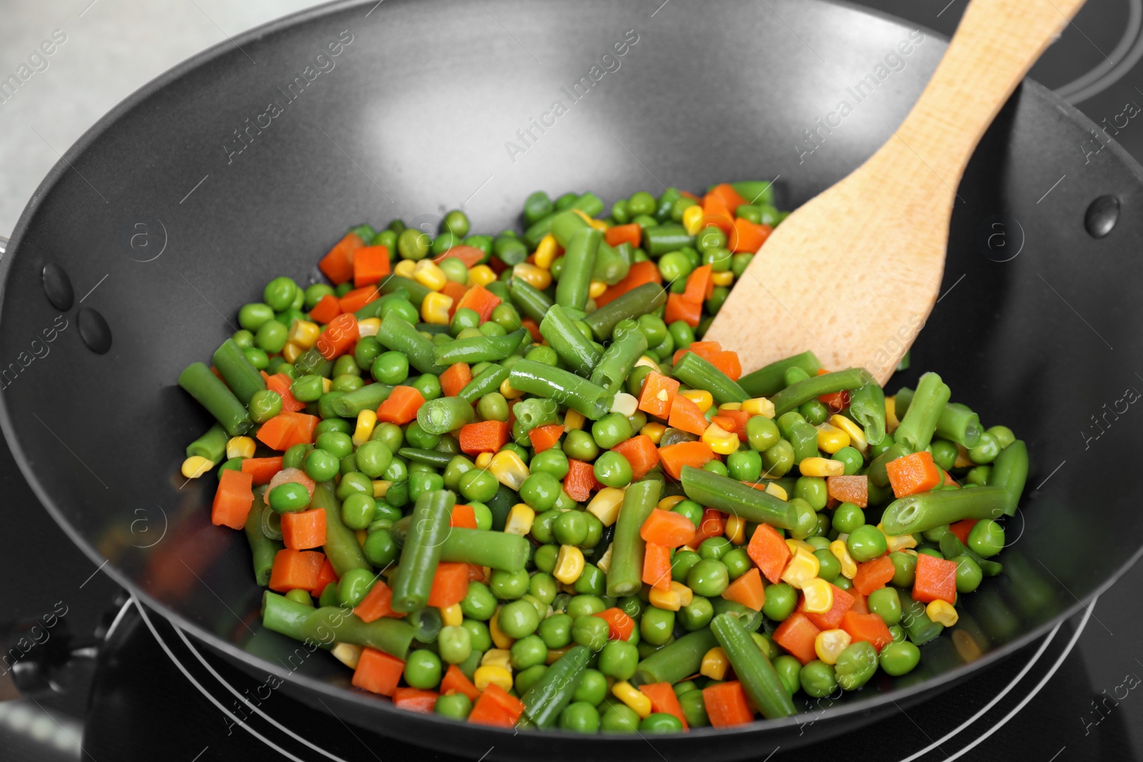 Photo of Cooking tasty vegetable mix in wok pan, closeup