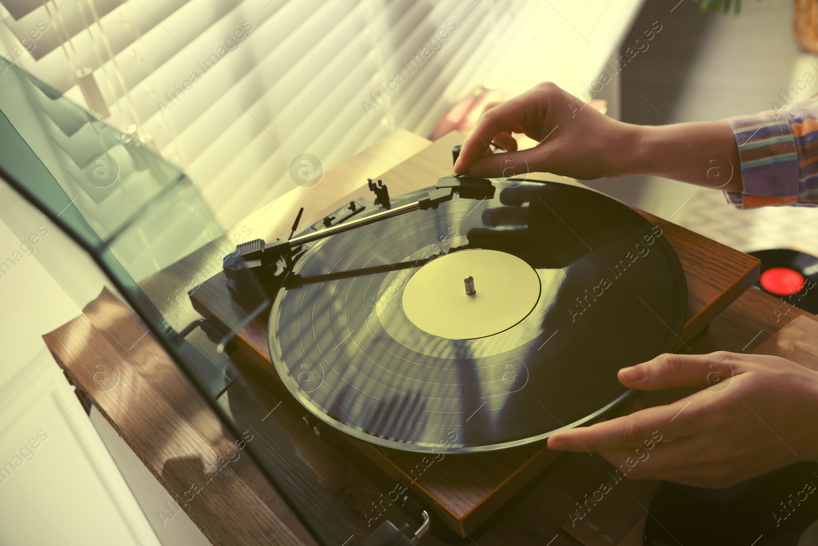 Image of Young woman using turntable at home, closeup