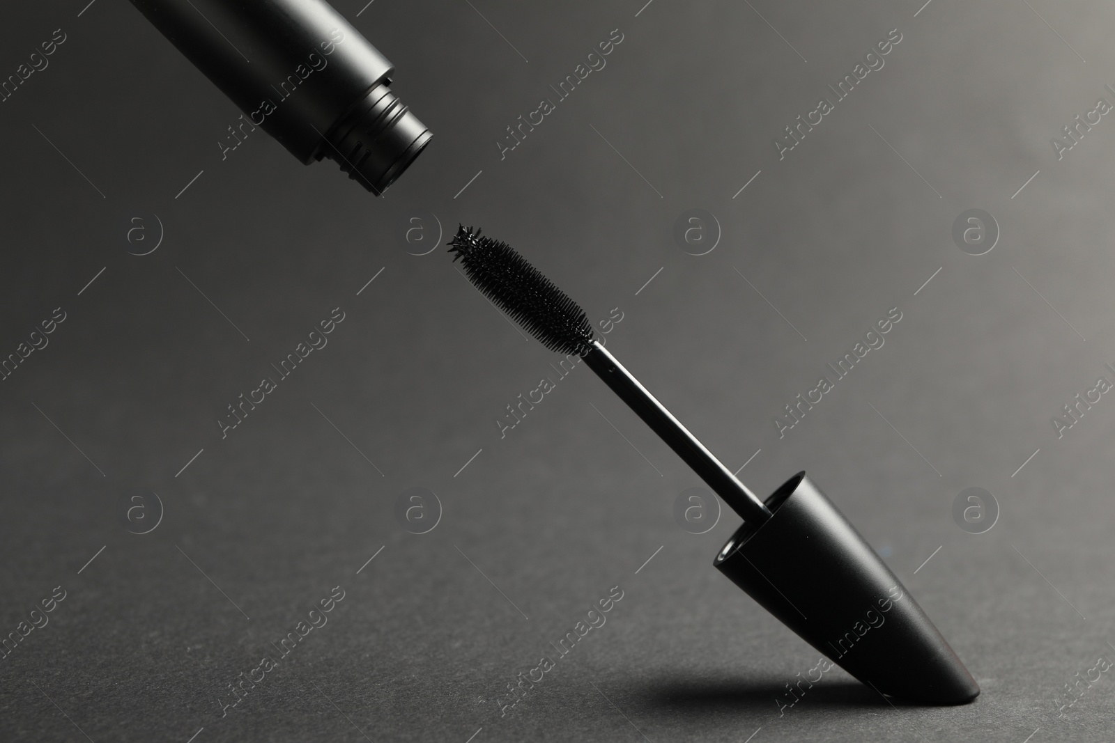 Photo of Black mascara with wand on grey background