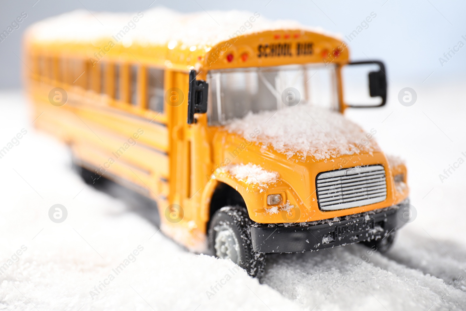 Photo of Yellow school bus on snowy road, closeup. Transport for students