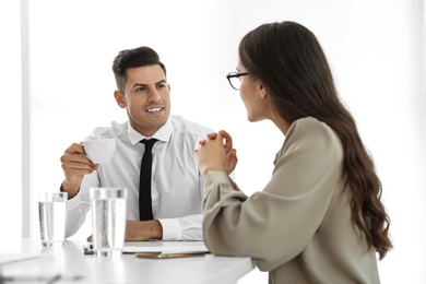 Photo of Office employees talking at table during meeting