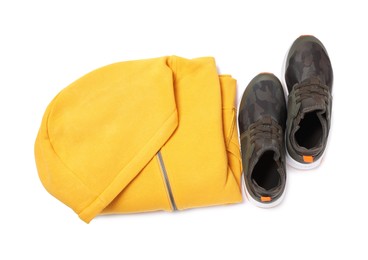 Yellow hoodie and sneakers on white background, top view