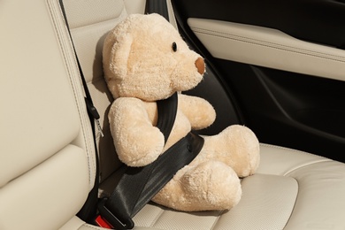 Photo of Cute stuffed toy bear buckled in backseat of car