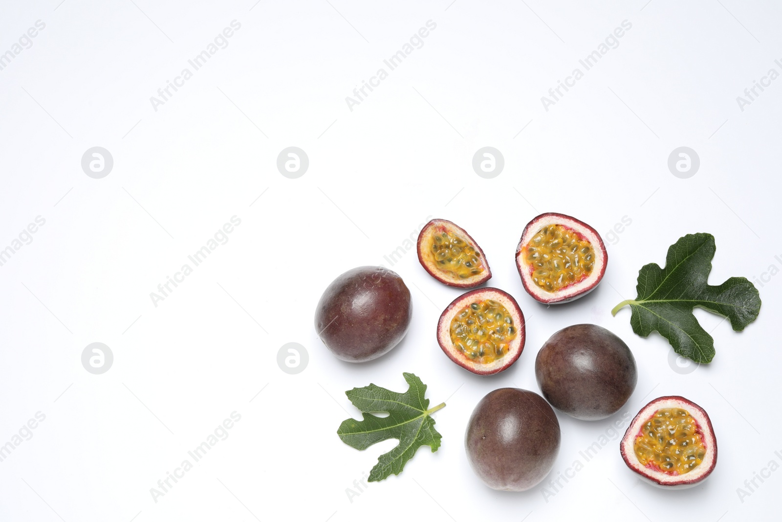 Photo of Fresh ripe passion fruits (maracuyas) with leaves on white background, flat lay