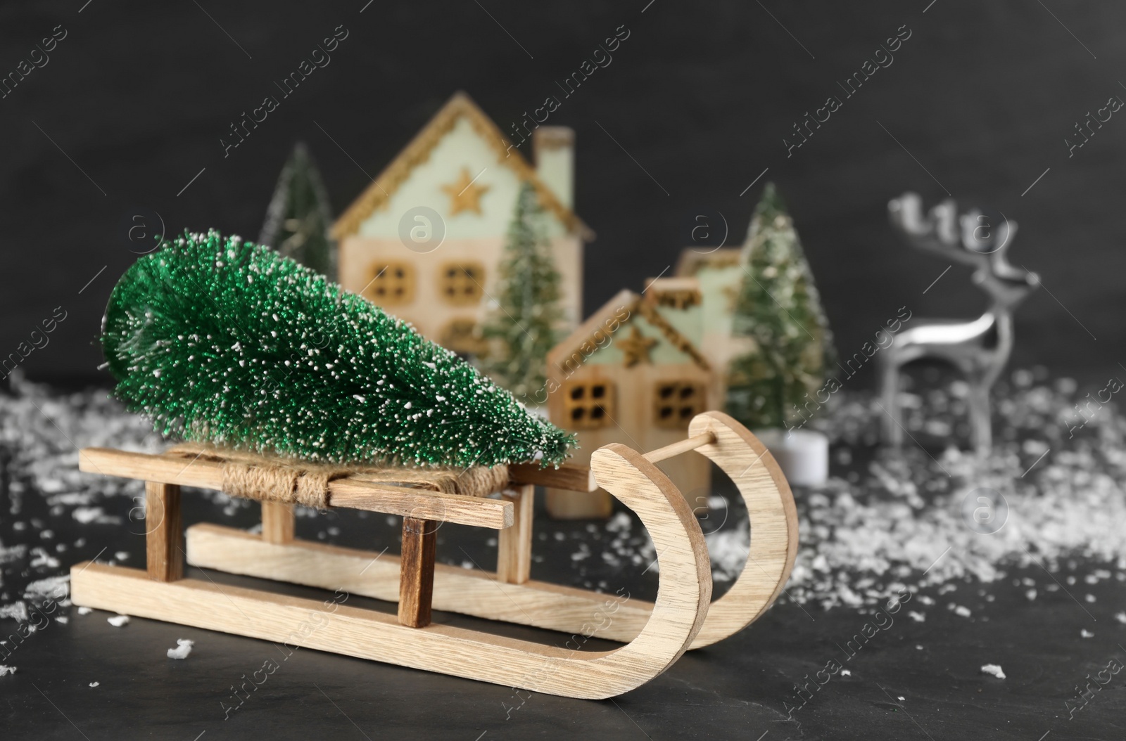 Photo of Beautiful Christmas composition with miniature sleigh on black slate table