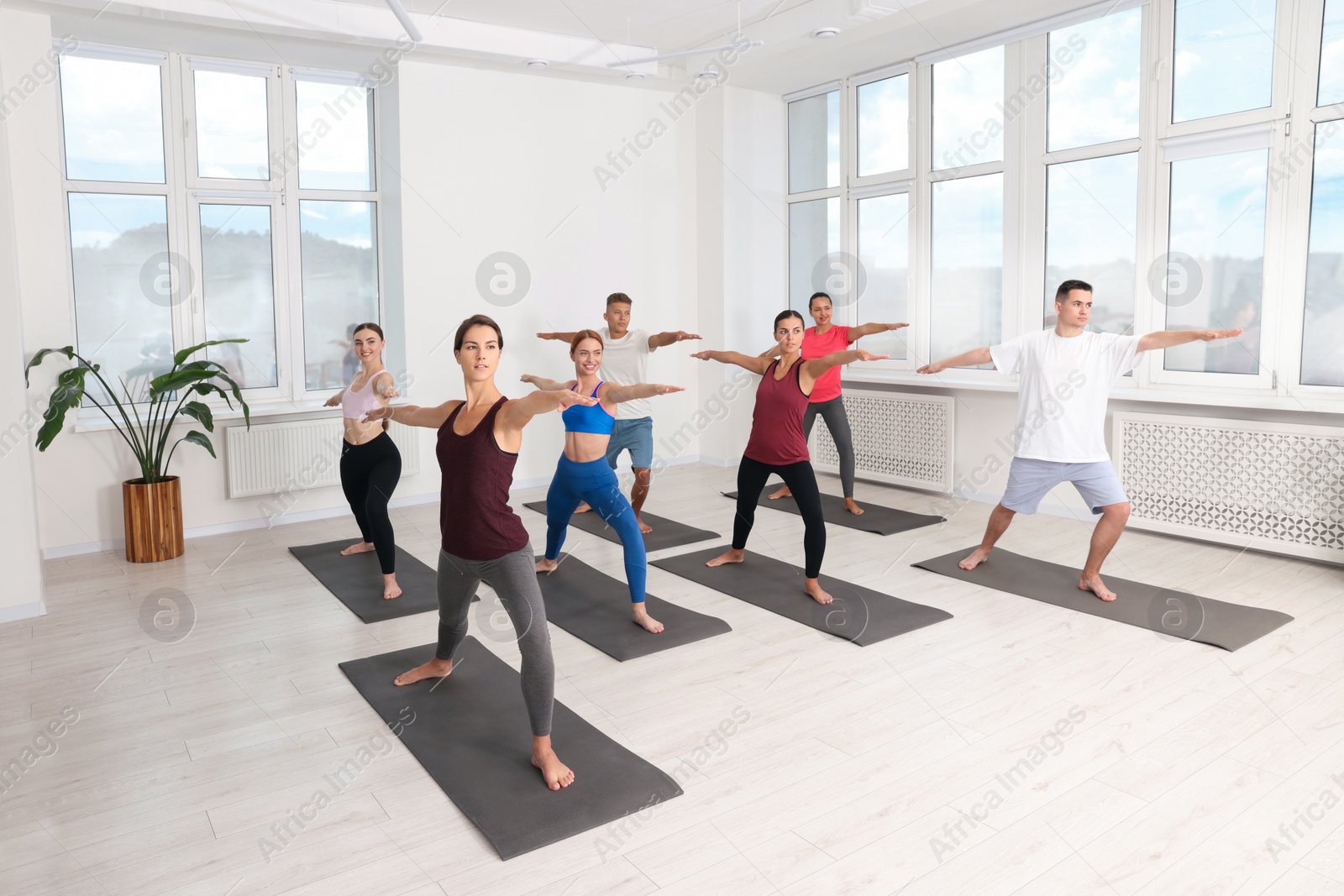 Photo of Group of people practicing yoga on mats indoors