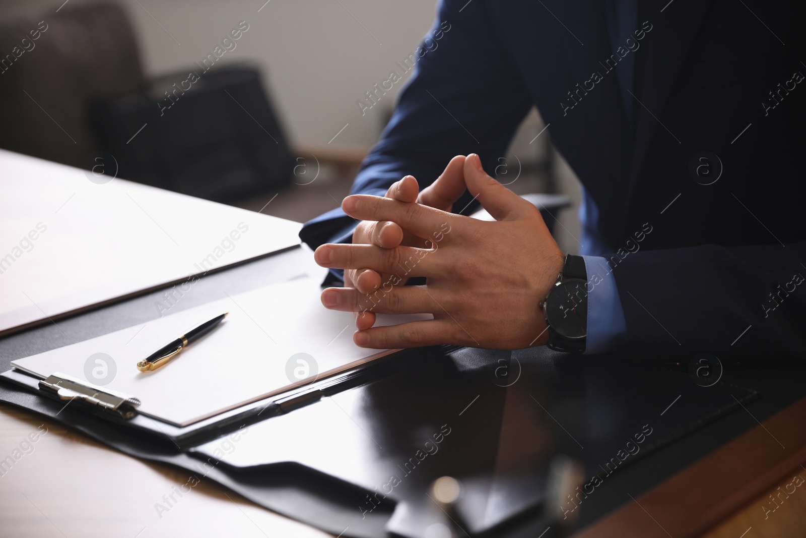 Photo of Male lawyer at table in office, closeup