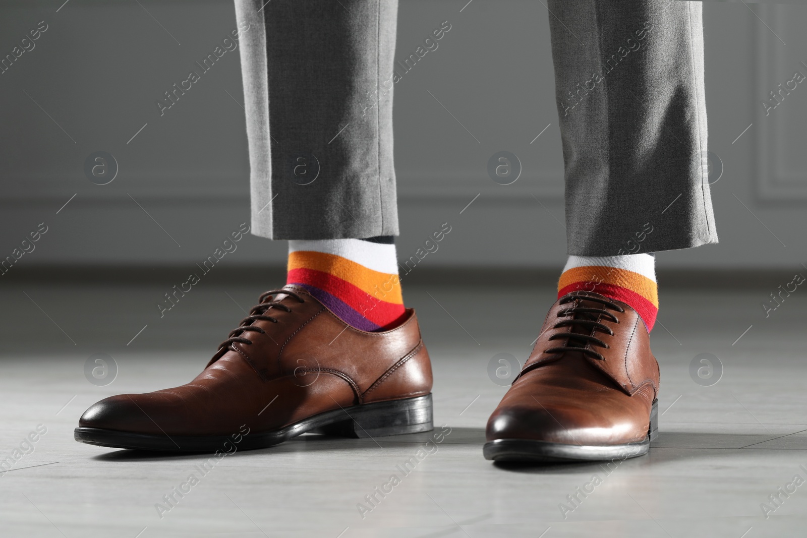 Photo of Man wearing stylish shoes and colorful socks indoors, closeup