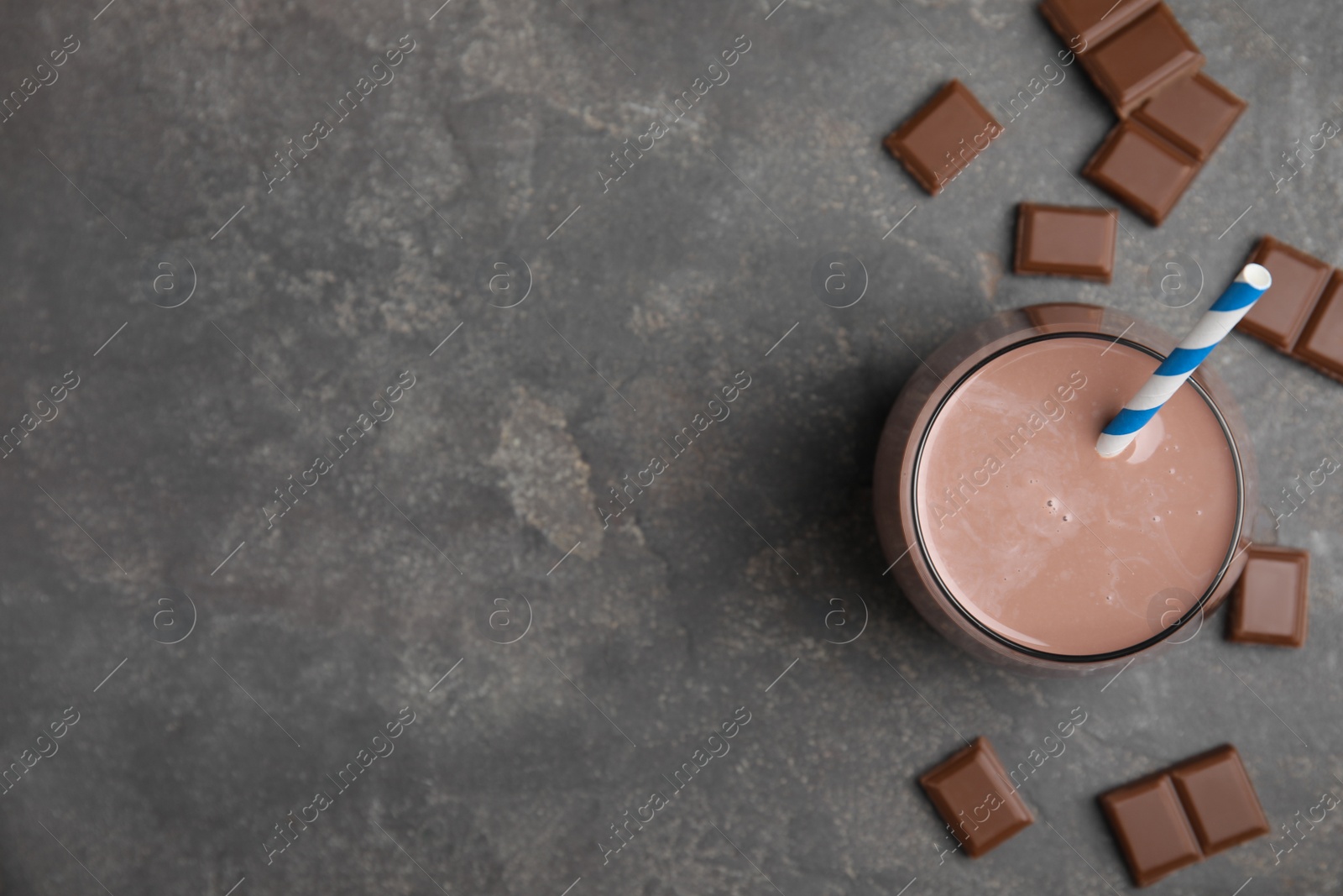 Photo of Delicious chocolate milk on grey table, flat lay. Space for text