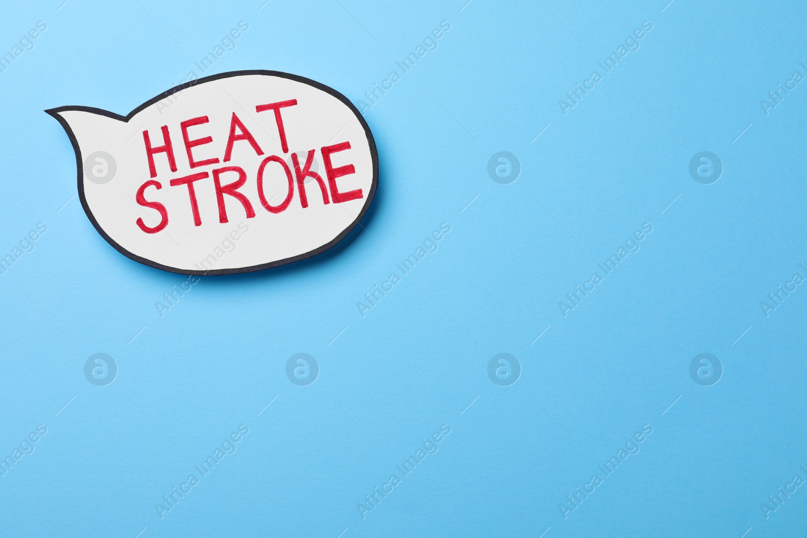 Photo of Paper speech balloon with words Heat Stroke on light blue background, top view. Space for text