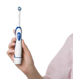 Woman holding electric toothbrush on white background, closeup