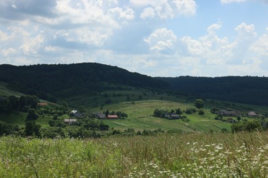 Beautiful landscape with village in mountains under blue sky