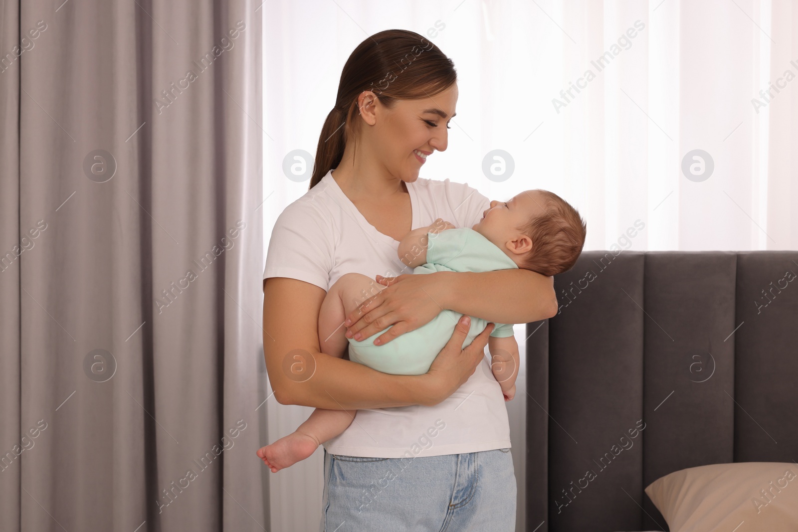 Photo of Mother holding her sleeping newborn baby at home