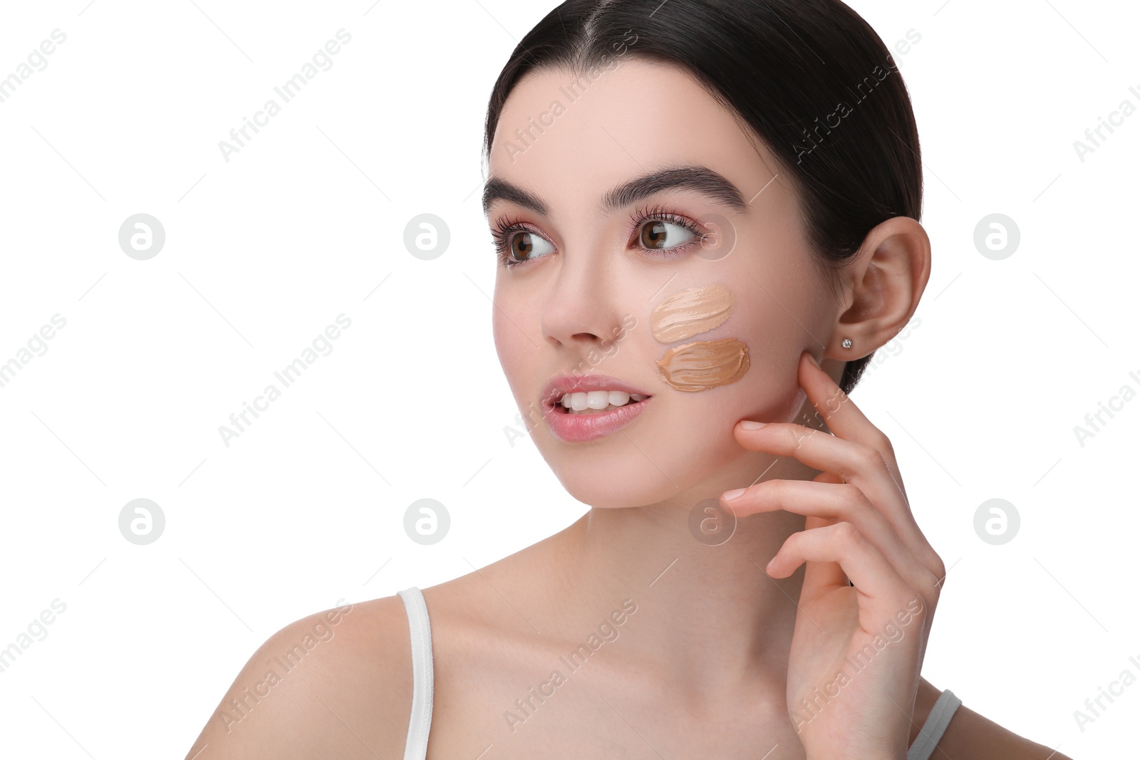 Photo of Teenage girl with swatches of foundation on face against white background