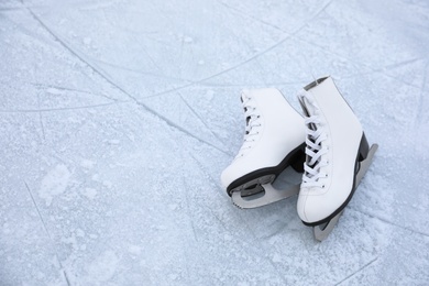 Photo of Figure skates with laces on ice, space for text. Winter outdoor activities