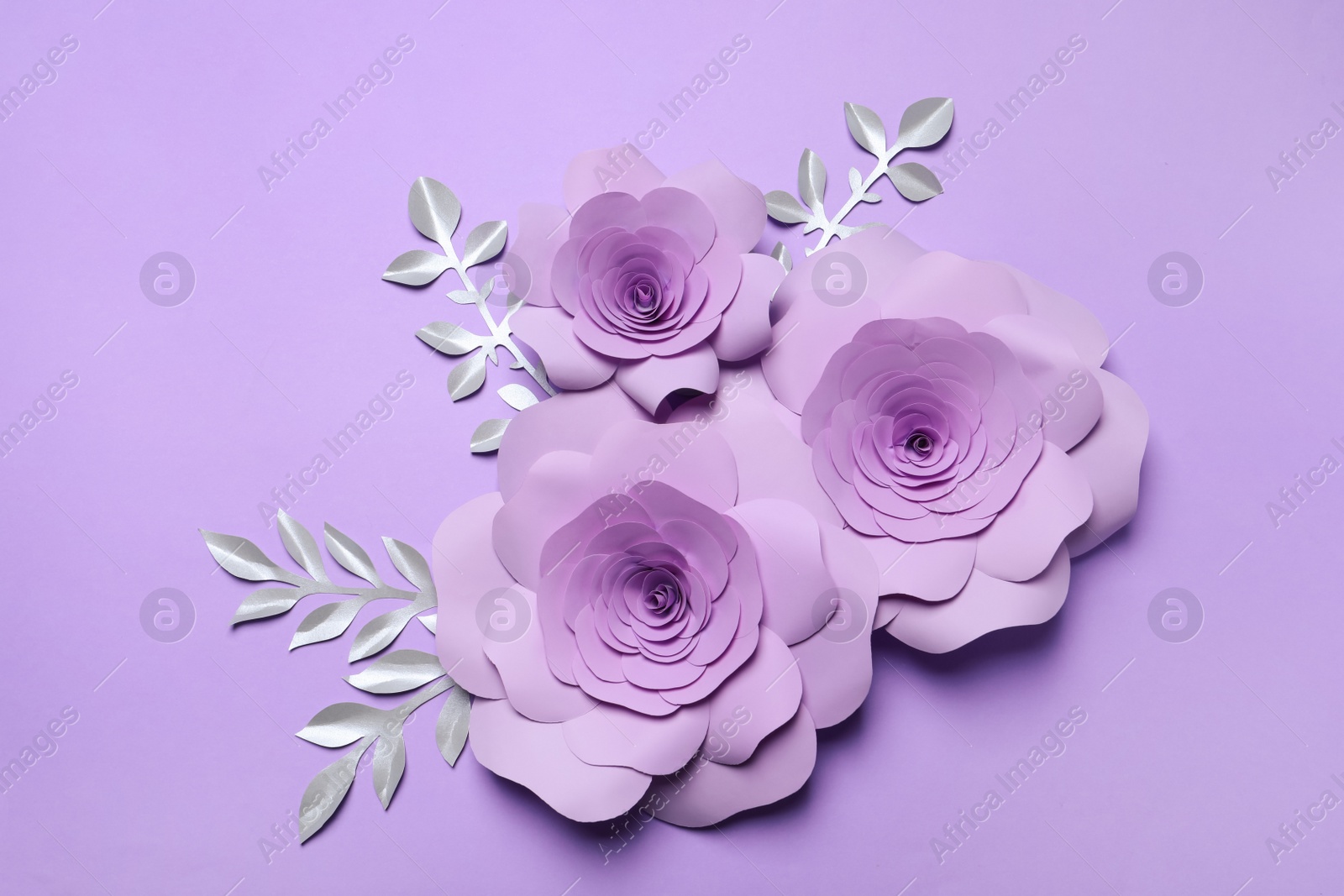 Photo of Beautiful flowers and branches made of paper on violet background, flat lay