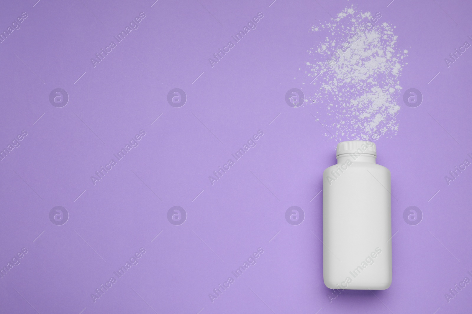 Photo of Bottle and scattered dusting powder on violet background, top view with space for text. Baby cosmetic product