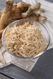 Grated horseradish and roots on grey wooden table