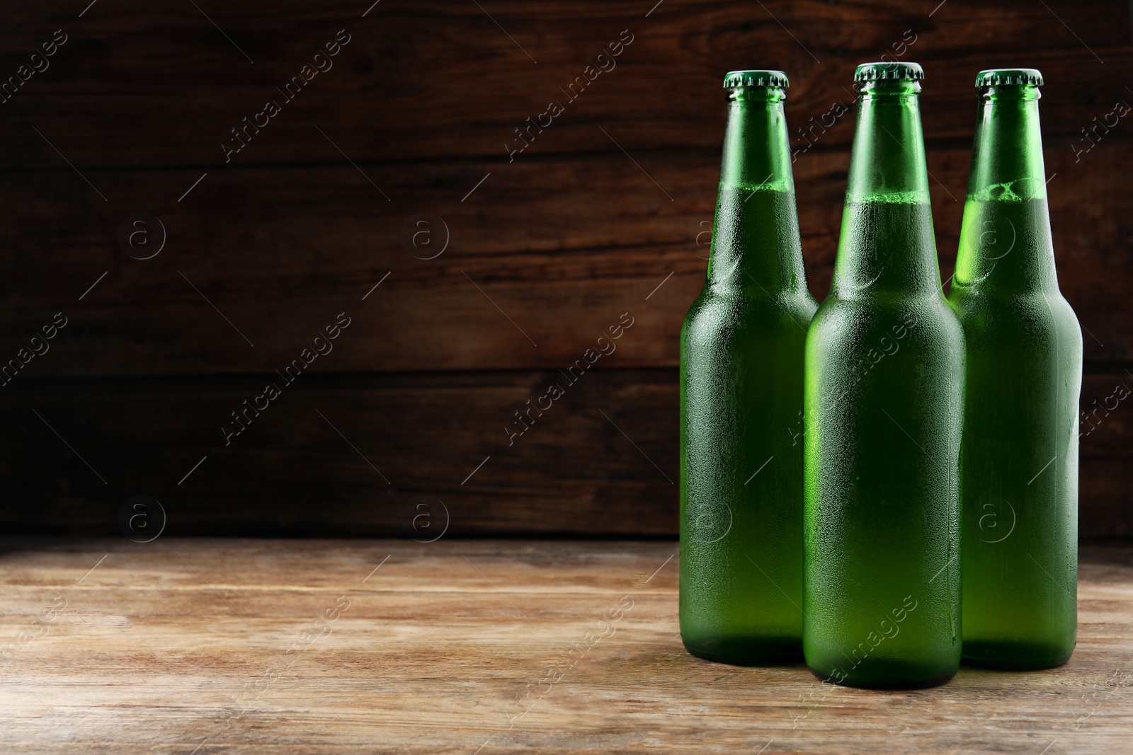 Photo of Many bottles of beer on wooden table, space for text