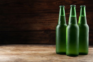 Many bottles of beer on wooden table, space for text