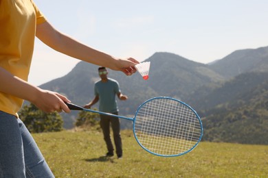 Couple playing badminton in mountains on sunny day