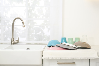 Photo of Clean dishes drying on counter in kitchen