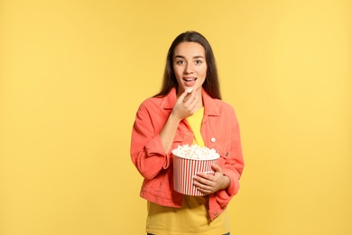 Photo of Woman with popcorn during cinema show on color background