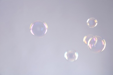 Beautiful translucent soap bubbles on grey background