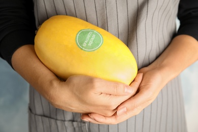 Photo of Woman holding spaghetti squash against color background, closeup