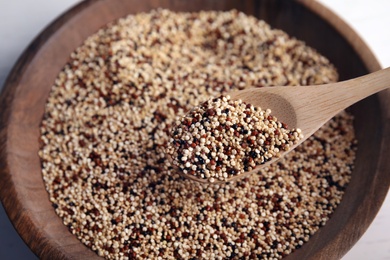 Photo of Spoon with mixed quinoa seeds over plate, closeup