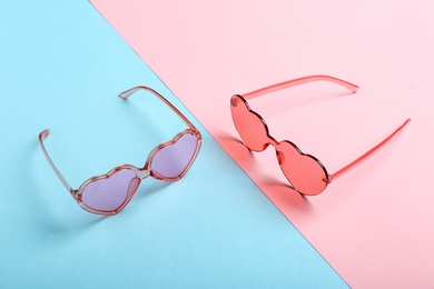 Photo of Funky heart shaped sunglasses on color background