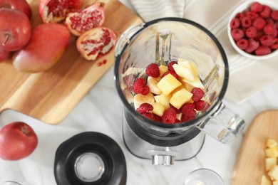 Photo of Blender with smoothie ingredients on white marble table in kitchen, above view