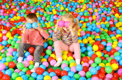 Cute children playing in ball pit indoors