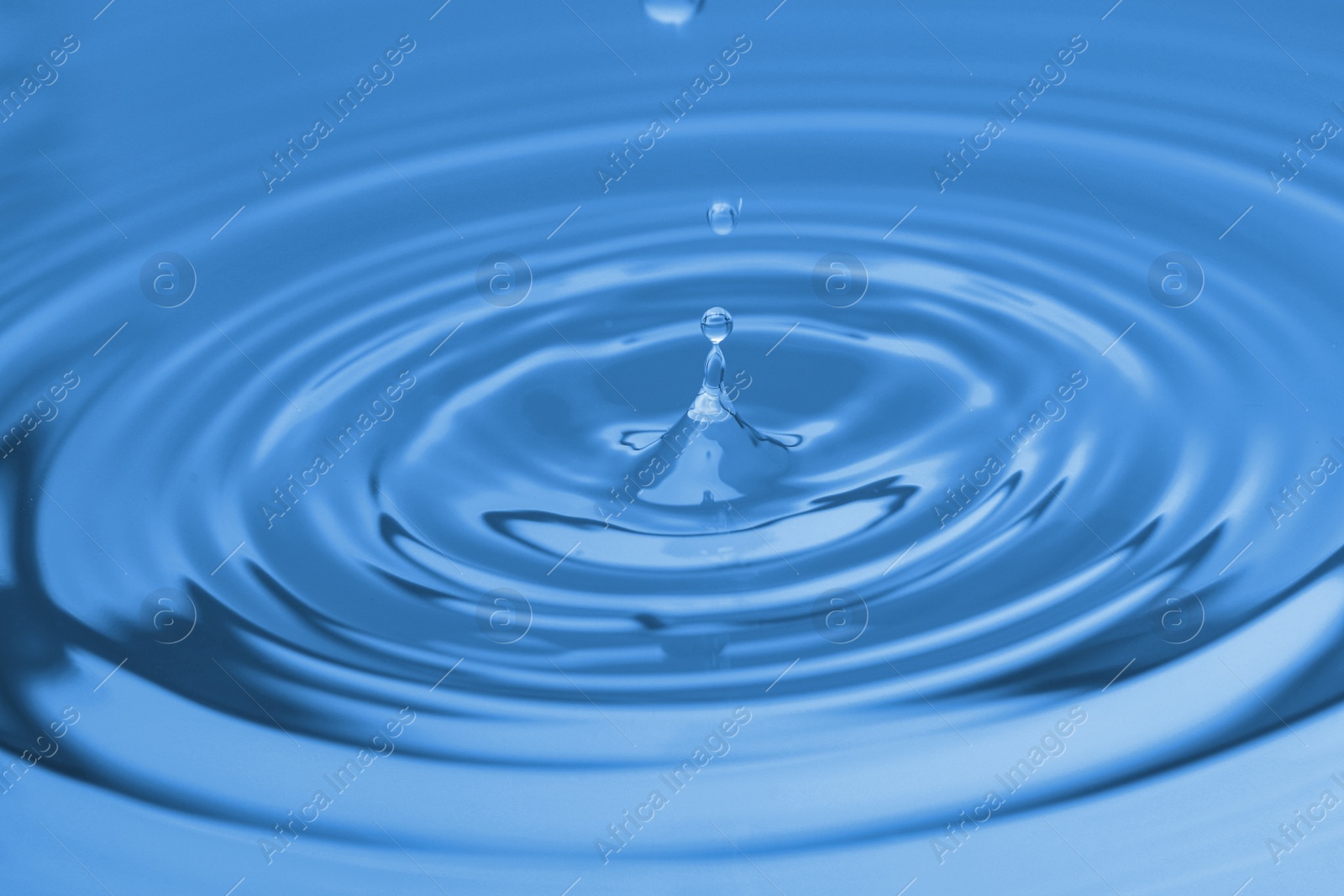 Photo of Splash of blue water with drop, closeup