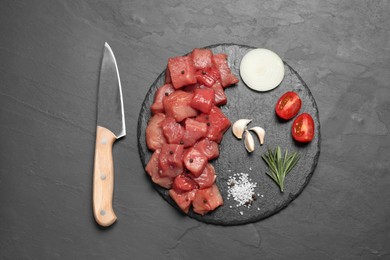 Photo of Raw beef meat, different ingredients for cooking delicious goulash and knife on black table, flat lay