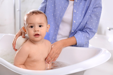 Photo of Mother with her little baby in bathroom