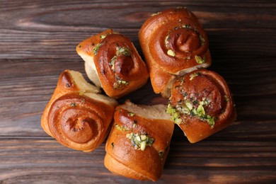 Photo of Tasty fresh pampushky. Traditional Ukrainian buns with garlic on wooden table, flat lay