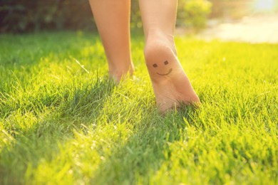 Photo of Teenage girl with smiling face drawn on heel walking outdoors, closeup