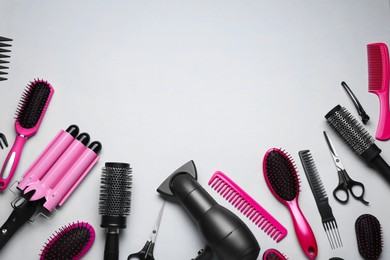 Flat lay composition of professional hairdresser tools on white background, space for text
